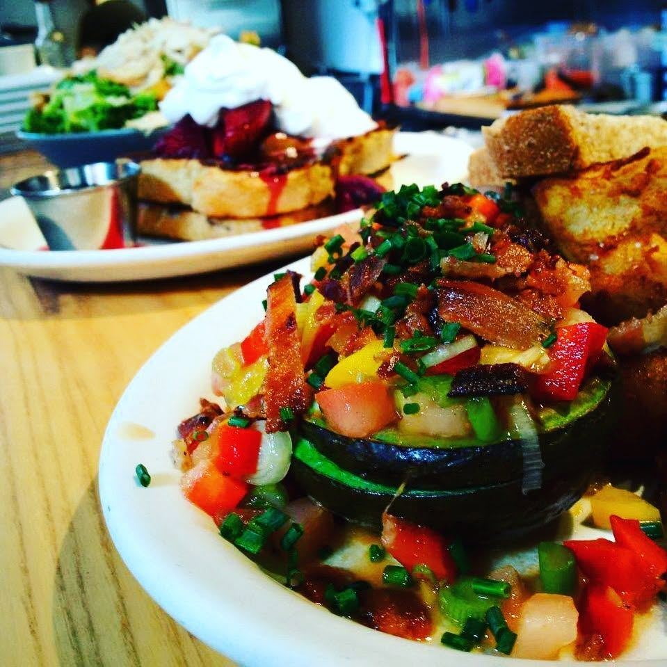 A daily special topped with bacon, peppers and green onion, with French toast behind