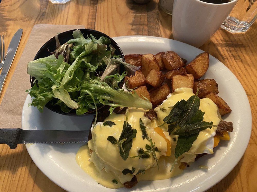 Duck confit eggs Benedict with hollandaise, crispy sage, home fries and greens
